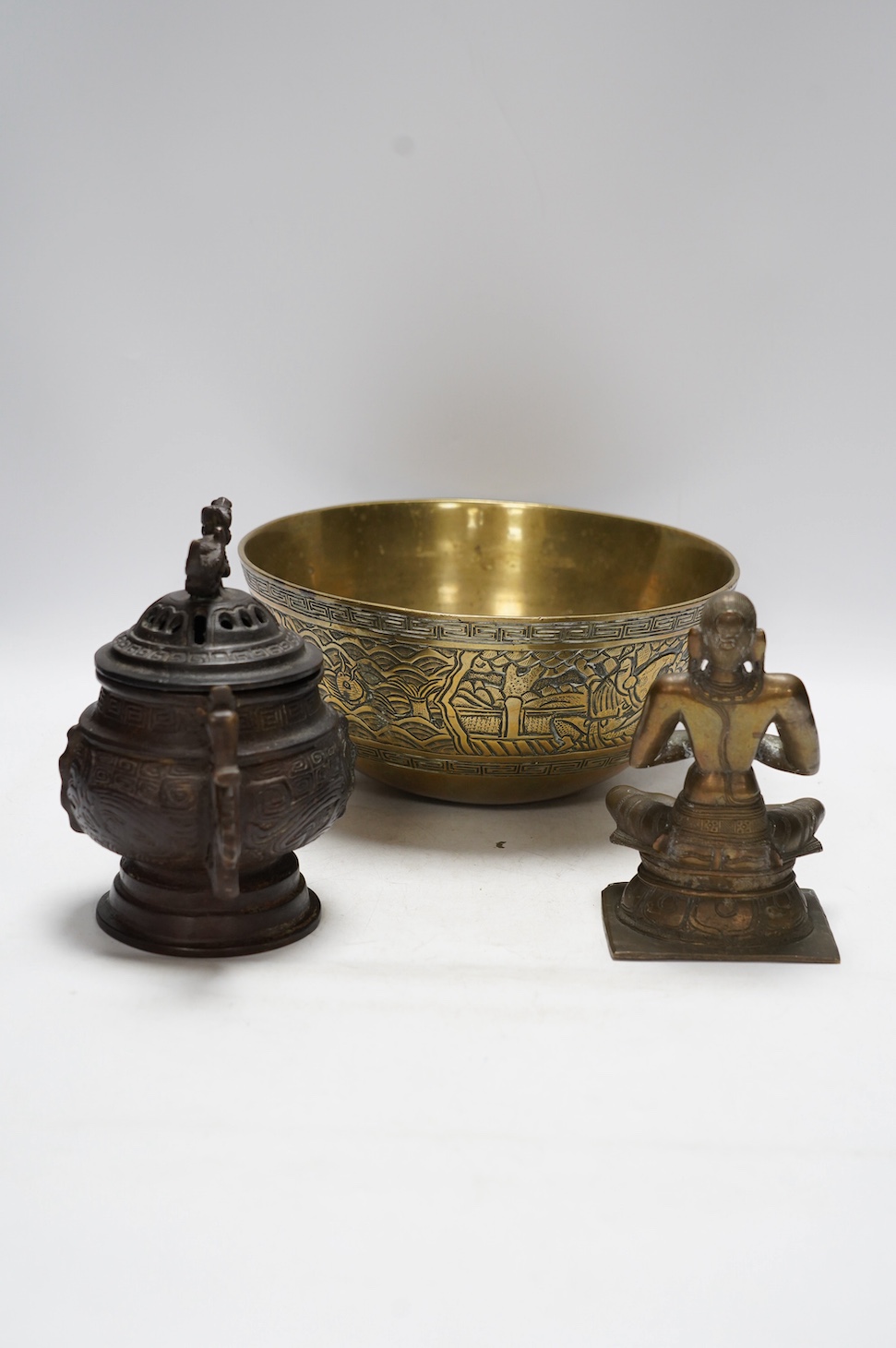 A Chinese bronze censer and cover, a Chinese bronze bowl and an Indian bronze seated deity, tallest 19cm high. Condition - fair some general scuffs and wear, the figure has a chip